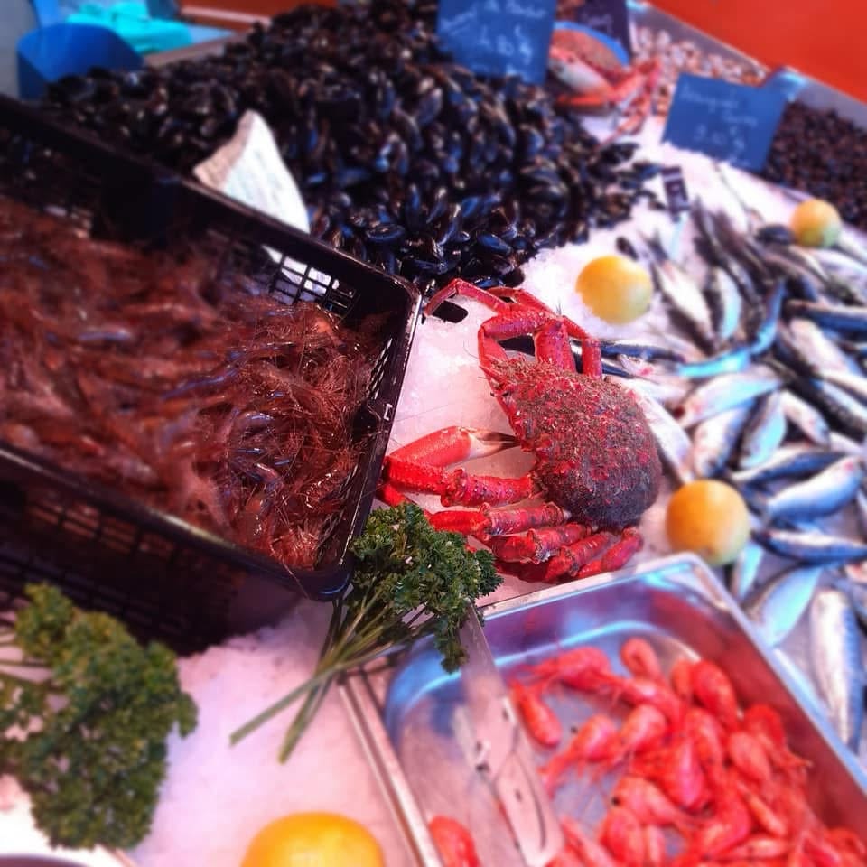 Étal de poissonnerie garni de poissons frais, crabes, crevettes et moules sur glace